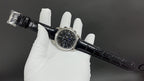 Patek Philippe watch angled view with black leather strap and buckle