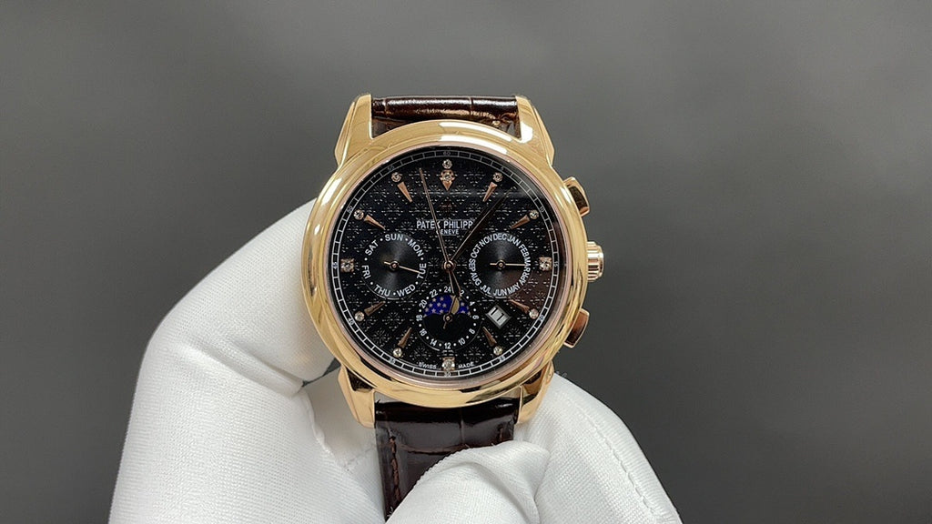Patek Philippe wristwatch with dark dial, gold bezel, brown leather strap on glove