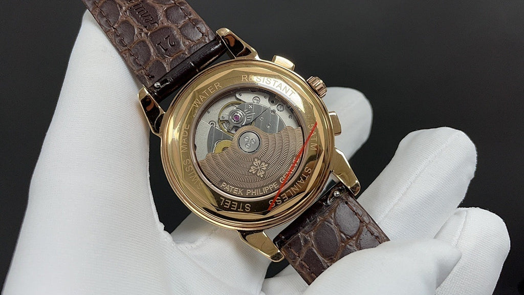 Patek Philippe wristwatch showing caseback, brown leather strap, gold accents