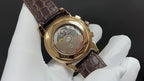 Patek Philippe wristwatch showing caseback, brown leather strap, gold accents
