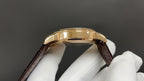 Patek Philippe wristwatch side view, gold case, brown leather strap