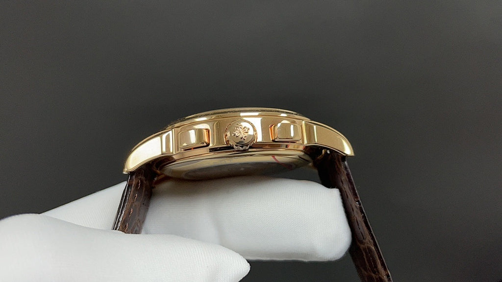 Patek Philippe wristwatch bezel close-up, gold case, brown leather strap