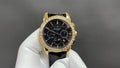 Patek Philippe wristwatch with black dial, gold case, and black leather strap