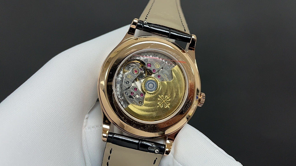 Patek Philippe wristwatch with exposed mechanical movement, gold case, and black strap