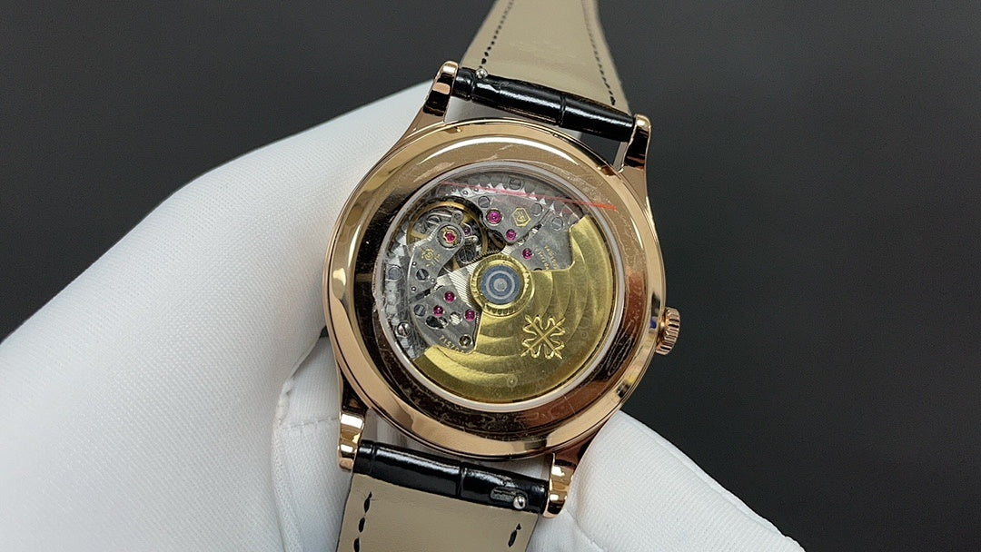 Patek Philippe wristwatch with exposed mechanical movement, gold case, and black strap