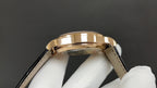 Patek Philippe wristwatch gold bezel and black leather strap, side angle