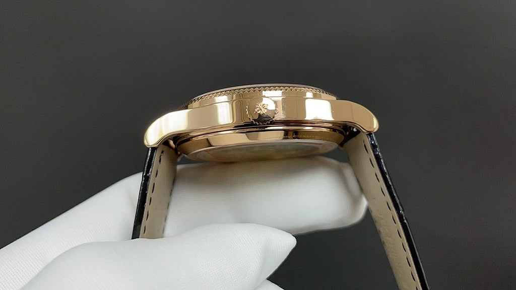 Patek Philippe wristwatch gold crown and black leather strap, close-up