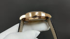 Patek Philippe wristwatch gold crown and black leather strap, close-up