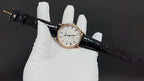 Patek Philippe wristwatch on black leather strap, side profile view