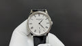 Patek Philippe watch with white dial, black leather strap, Roman numerals, subdial