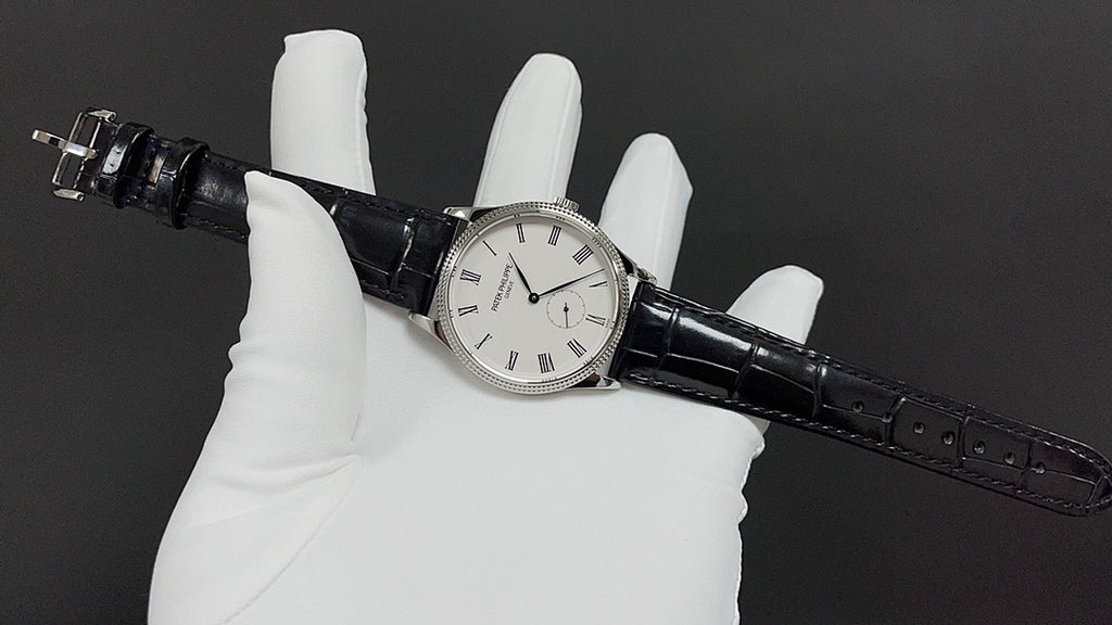 Wristwatch with black leather strap, round silver case, white dial with markers