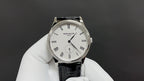 Patek Philippe watch showing white dial and black leather strap with Roman numerals