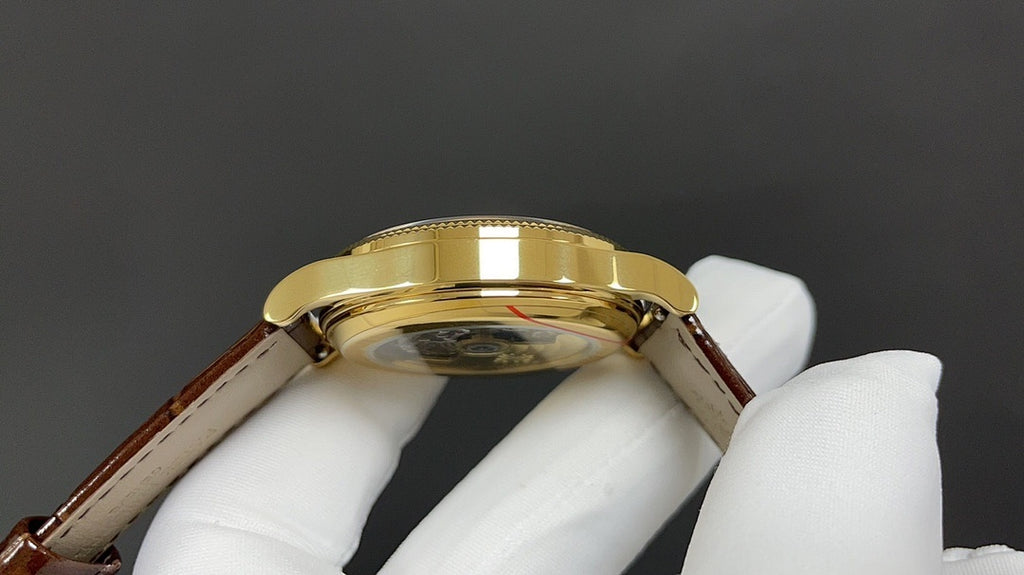Patek Philippe watch case from above, gold bezel and brown leather strap ends