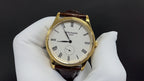 Patek Philippe watch front view, gold case, white dial with subdial, brown leather strap