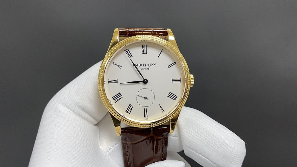 Patek Philippe watch with white dial and black hands, gold case, brown leather strap