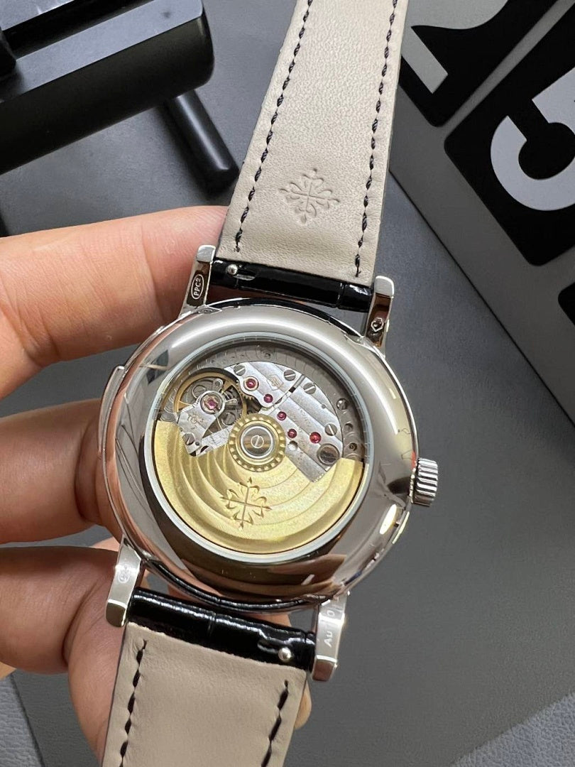 Patek Philippe wristwatch caseback on cream leather strap with engraved back