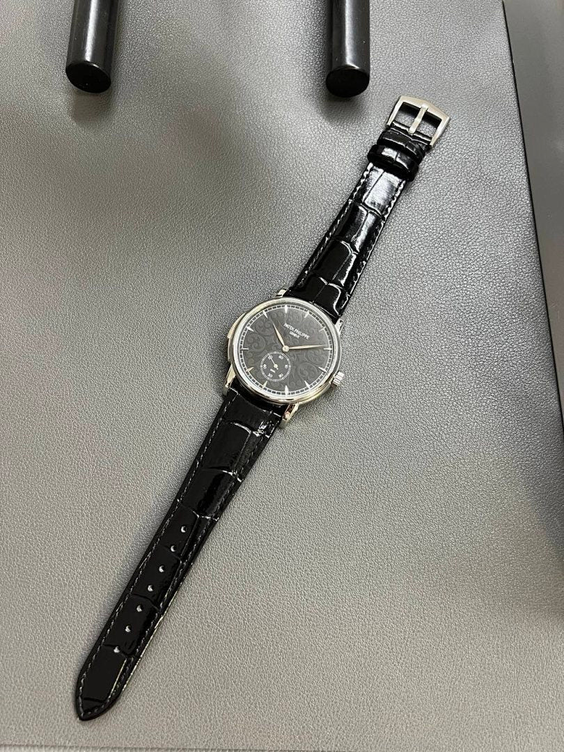 Patek Philippe wristwatch with dark leather strap and silver-tone dial