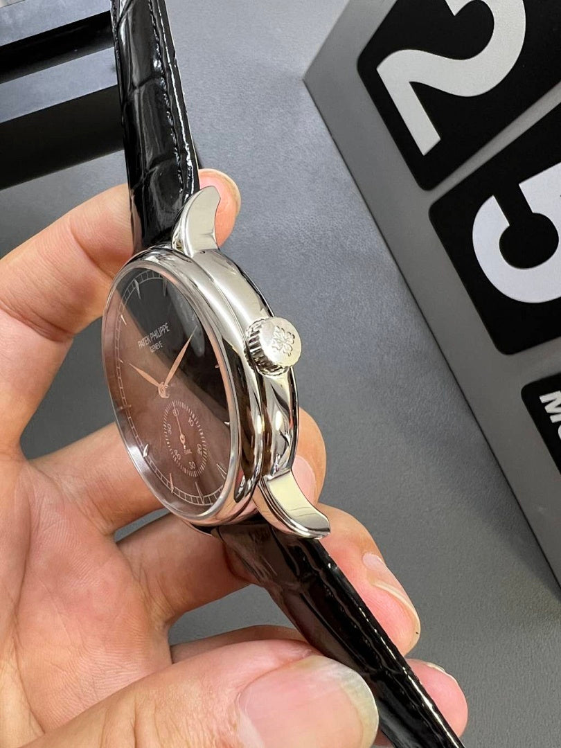 Patek Philippe wristwatch with silver case and black leather strap, crown visible