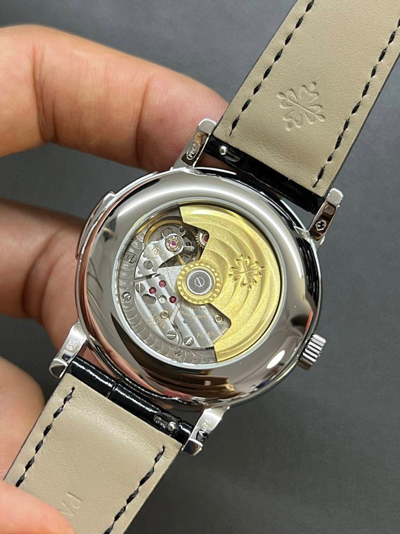 Patek Philippe watch case back showing mechanical movement through clear window