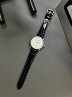 Patek Philippe watch with black leather strap and white dial, silver-tone crown and bezel