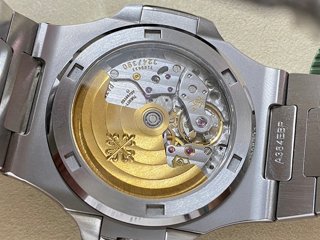 Patek Philippe watch case interior view with gold-toned movement and steel bracelet