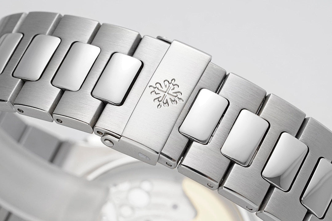 Patek Philippe stainless steel link bracelet with engraved emblem at center link.