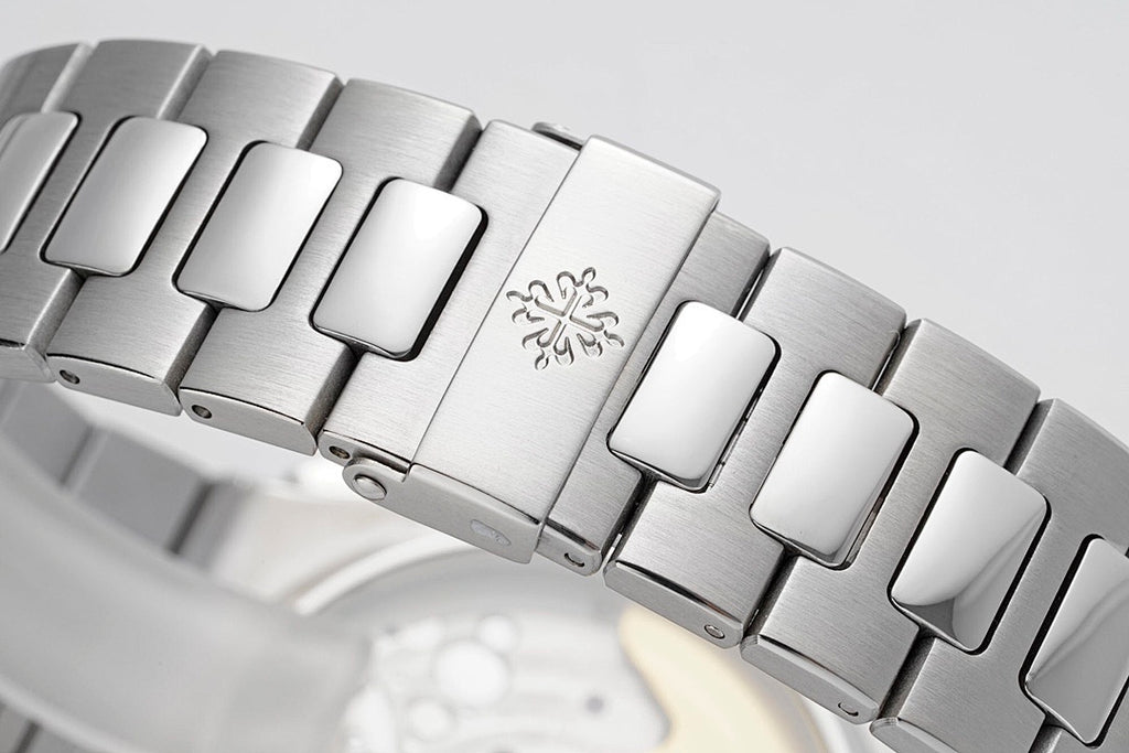 Stainless steel bracelet detail with engraved clasp and alternating polished links.