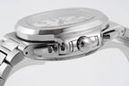 Stainless steel watch case close-up with crown and pushers on the side.