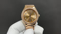 Gold-tone wristwatch with champagne dial, diamond bezel, and metal link bracelet