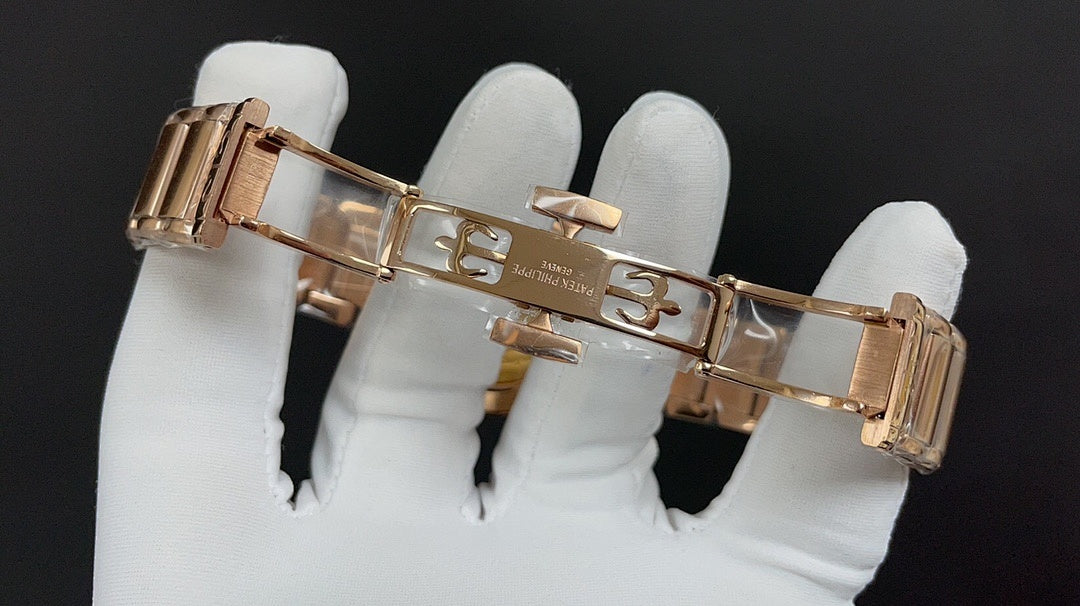 Rose-gold wristwatch with metal link bracelet and clasp, side view