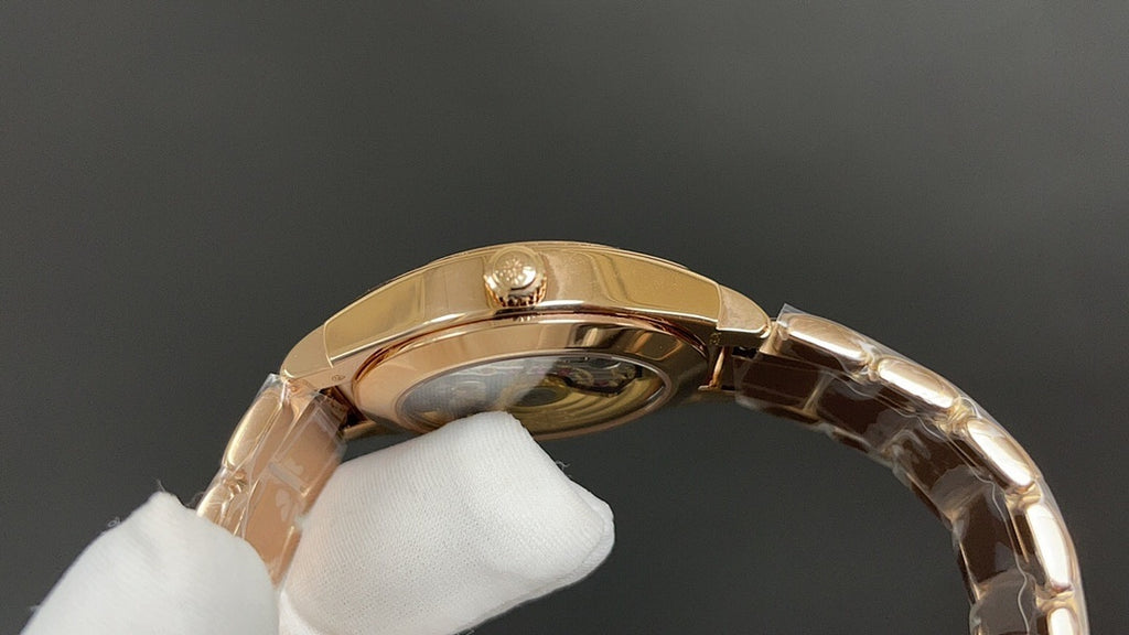 Gold-tone wristwatch caseback close-up with crown and metal link bracelet