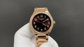 Gold-tone Patek Philippe watch with brown dial, diamond bezel, and metal bracelet