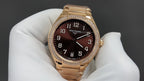 Gold-tone Patek Philippe watch with brown dial, raised numerals, and diamond bezel