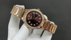 Gold-tone Patek Philippe watch with dark brown dial and wide ridged bracelet links