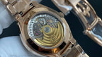 Patek Philippe watch close-up with see-through case back and gold-tone movement details.