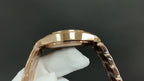 Patek Philippe watch case top in gold tone with metal bracelet links.