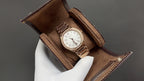 Patek Philippe watch in brown presentation case, white dial on metal bracelet.