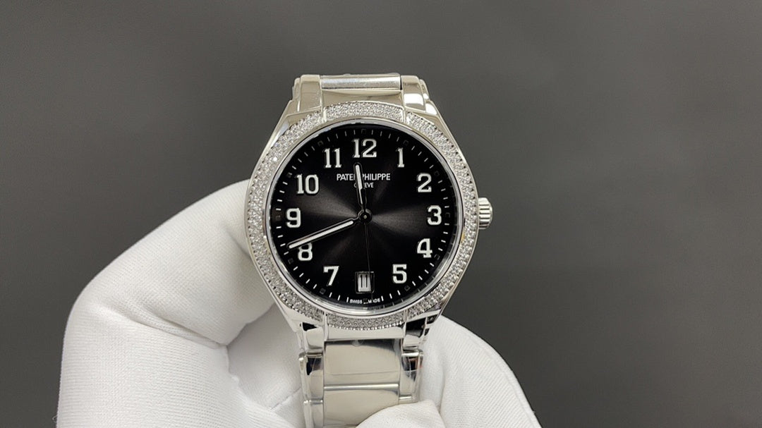 Patek Philippe watch with black dial, silver metal bracelet, diamond-studded bezel.