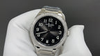 Patek Philippe watch with black dial, silver bracelet, diamond bezel.