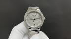 Patek Philippe watch with silver metal bracelet, jeweled bezel, white dial