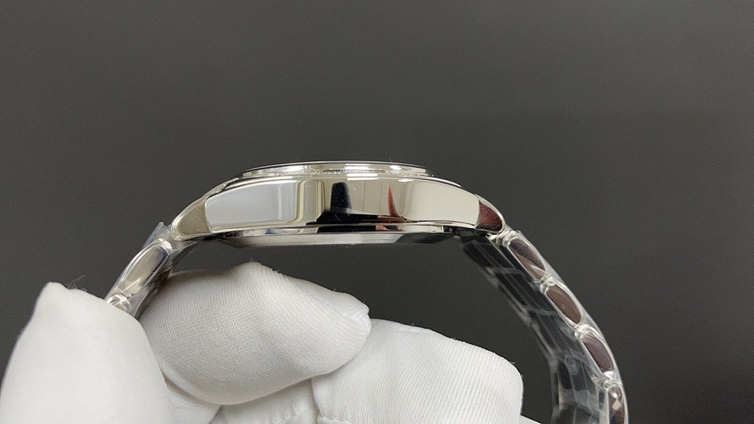 Polished metal watch case profile with curved bezel, held in white gloves