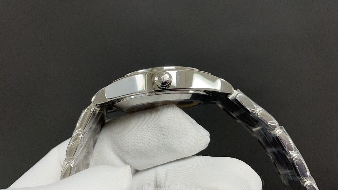 Silver wristwatch case with crown and bracelet links on glove hand