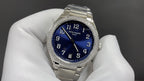 Silver wristwatch with blue dial and diamond bezel on metal bracelet