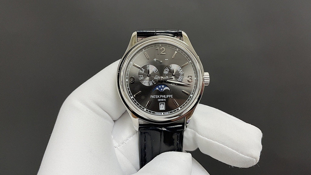 Patek Philippe wristwatch with black dial, silver-tone case, black leather strap