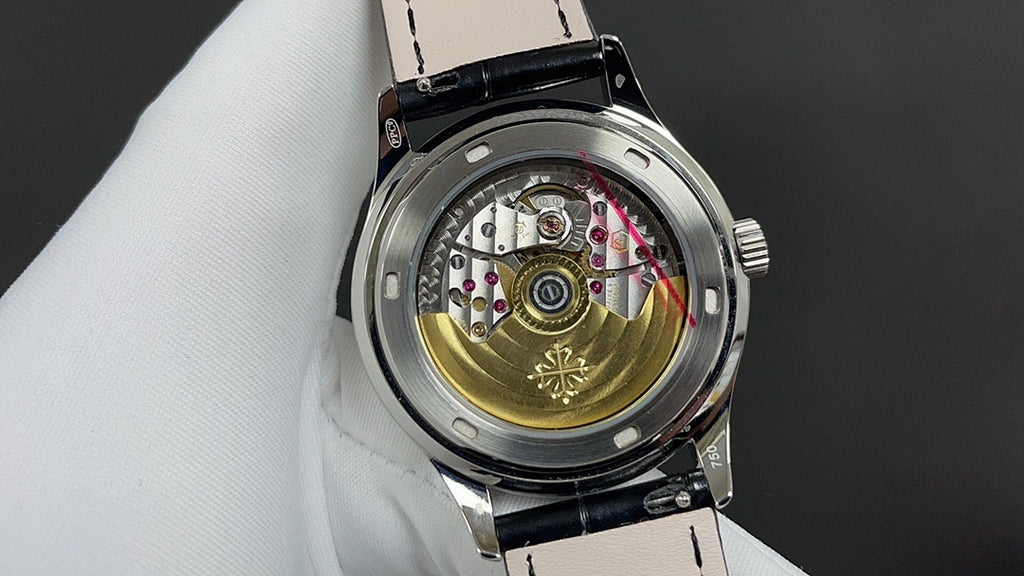 Patek Philippe wristwatch open caseback with mechanical movement, black leather strap