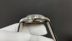 Patek Philippe wristwatch caseback view with crown and lugs, polished silver-tone, black strap
