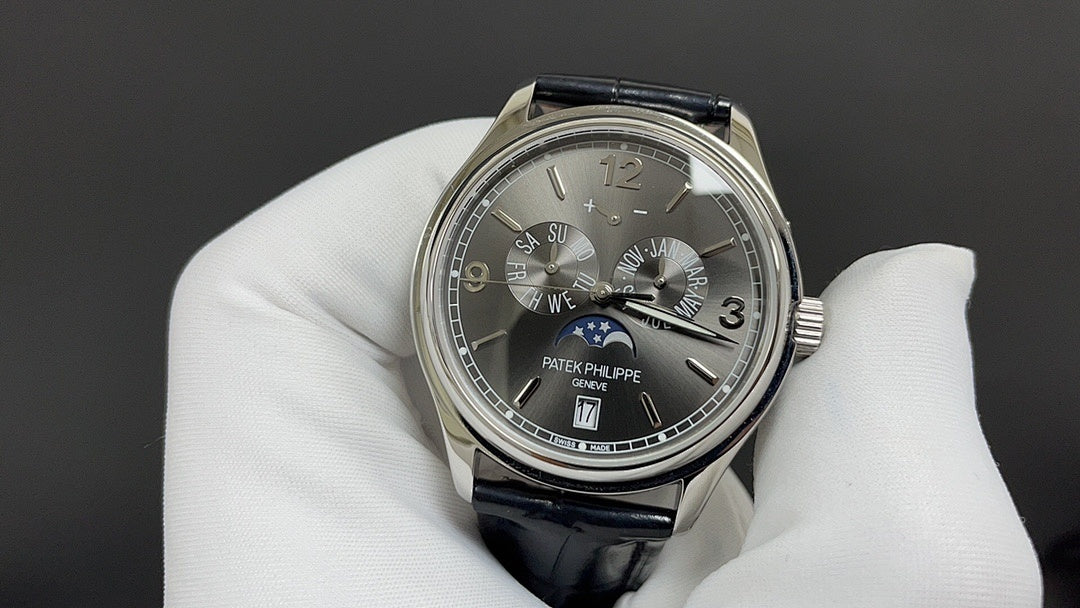 Patek Philippe wristwatch with dark dial, Roman numerals, black leather strap, silver case