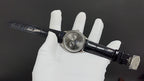 Patek Philippe wristwatch side view with black leather strap and clasp, silver-tone case