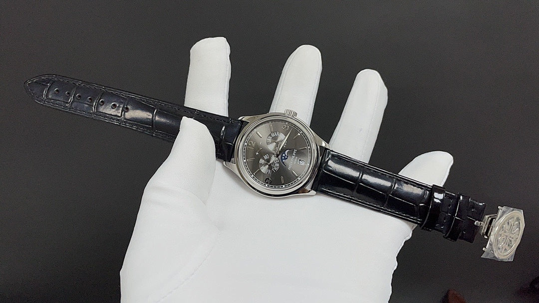 Patek Philippe wristwatch side view with black leather strap and clasp, silver-tone case