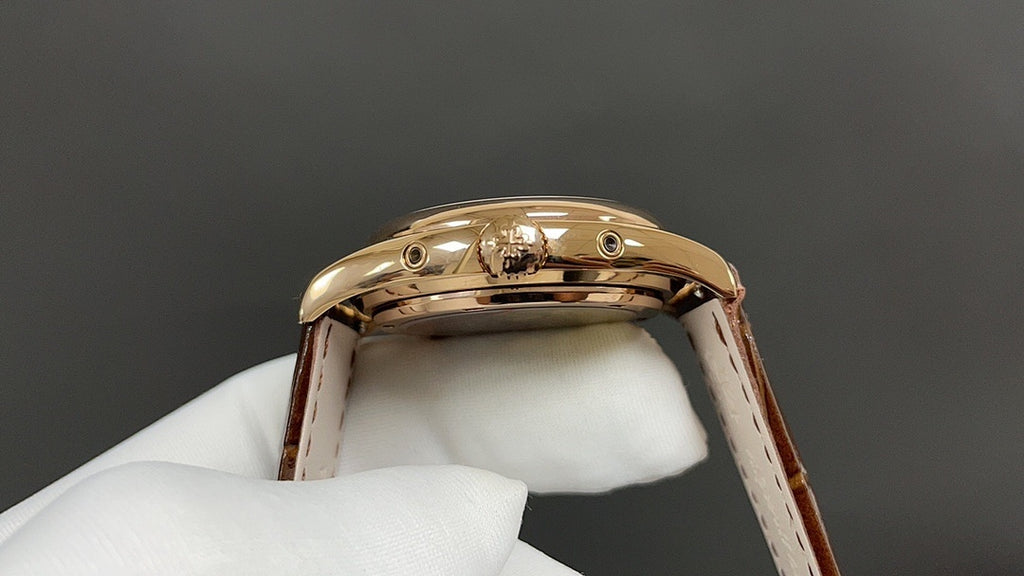 Gold-tone wristwatch case back on brown leather strap
